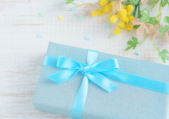 青いパッケージのギフトと花束